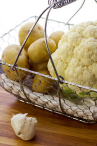 cauliflower and yukon gold potatoes in basket prepping for cauliflower mashed potato recipe