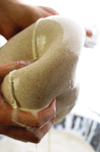 Squeezing out homemade nut milk made from cashews and almonds!