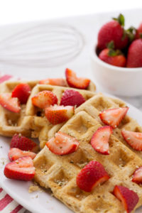 Adding strawberries and hemp seeds to easy vegan waffle recipe