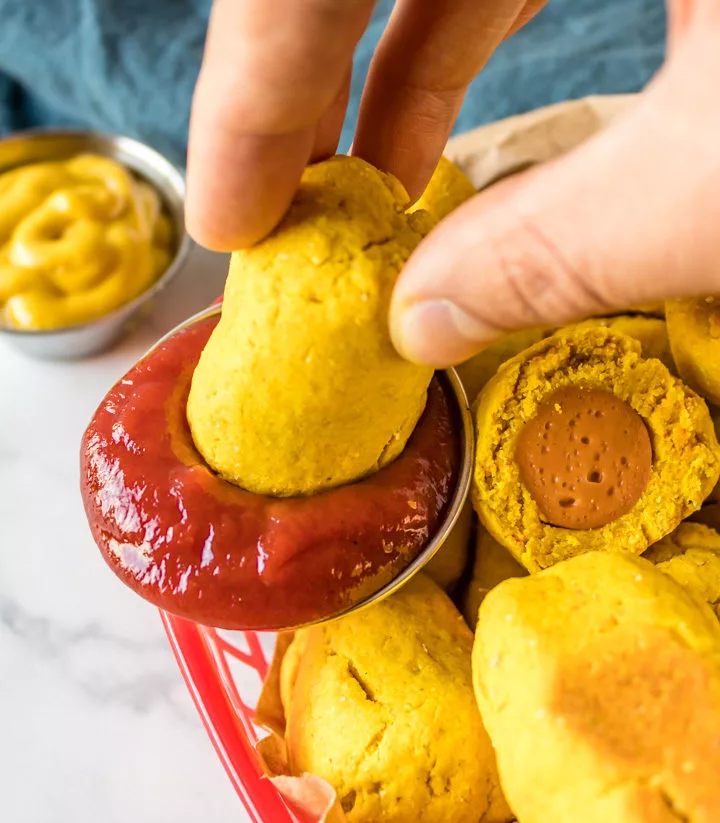 vegan corn dog bite dipping in ketchup
