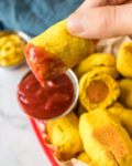 Dipping the easiest vegan corn dog recipe in ketchup